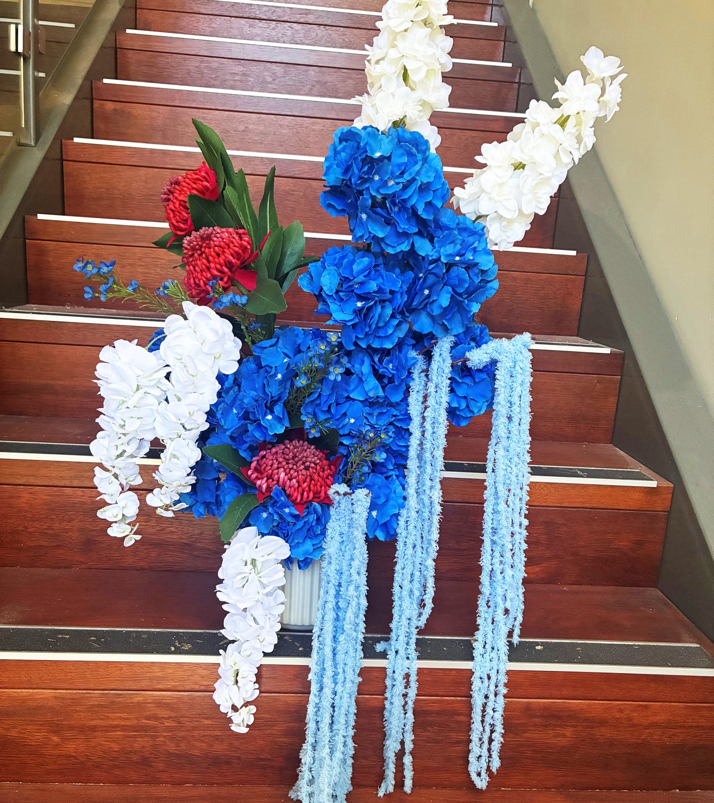 blue and red artificial flower arrangement with hydrangeas